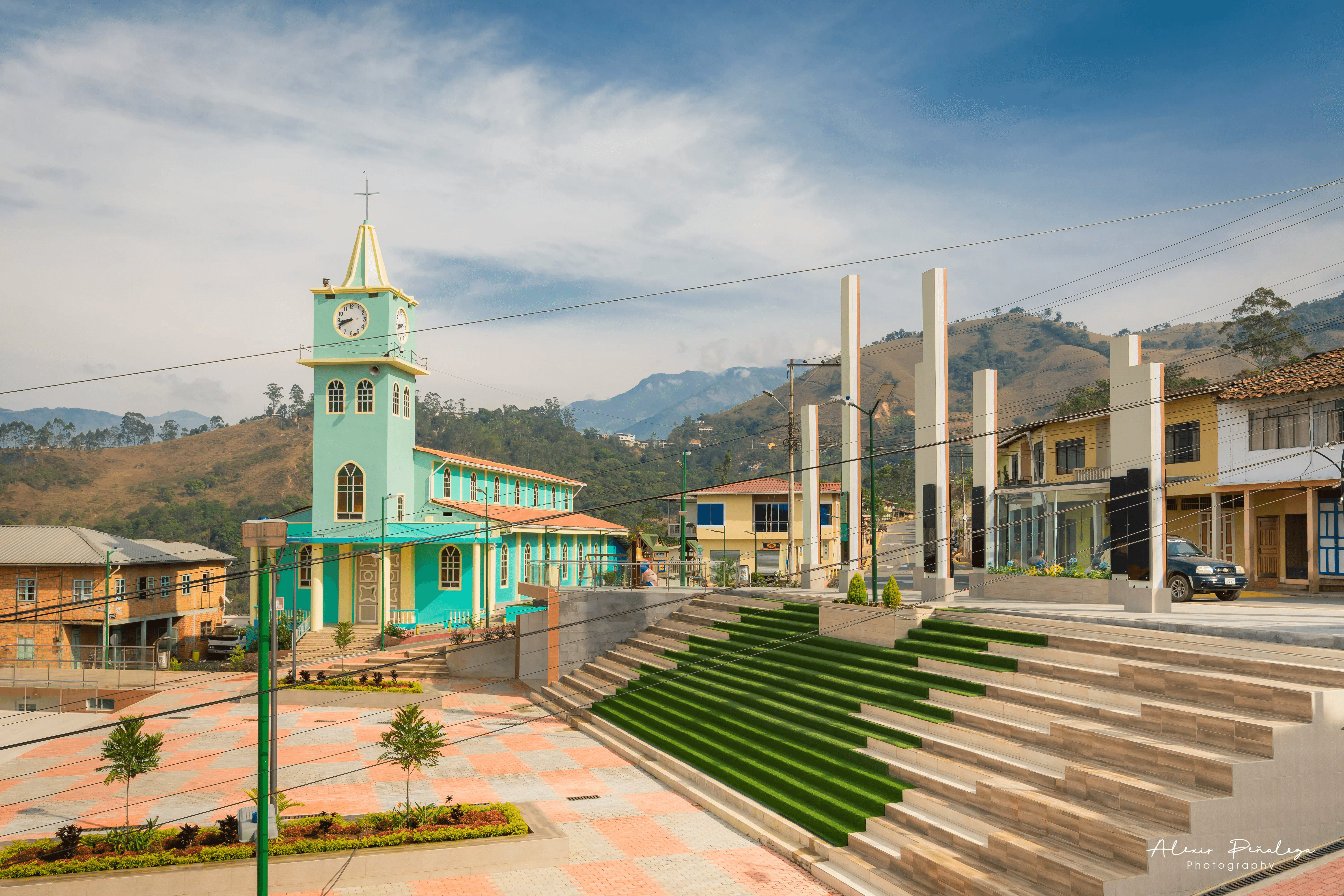 Plaza central con escalinatas verdes y pilares blancos