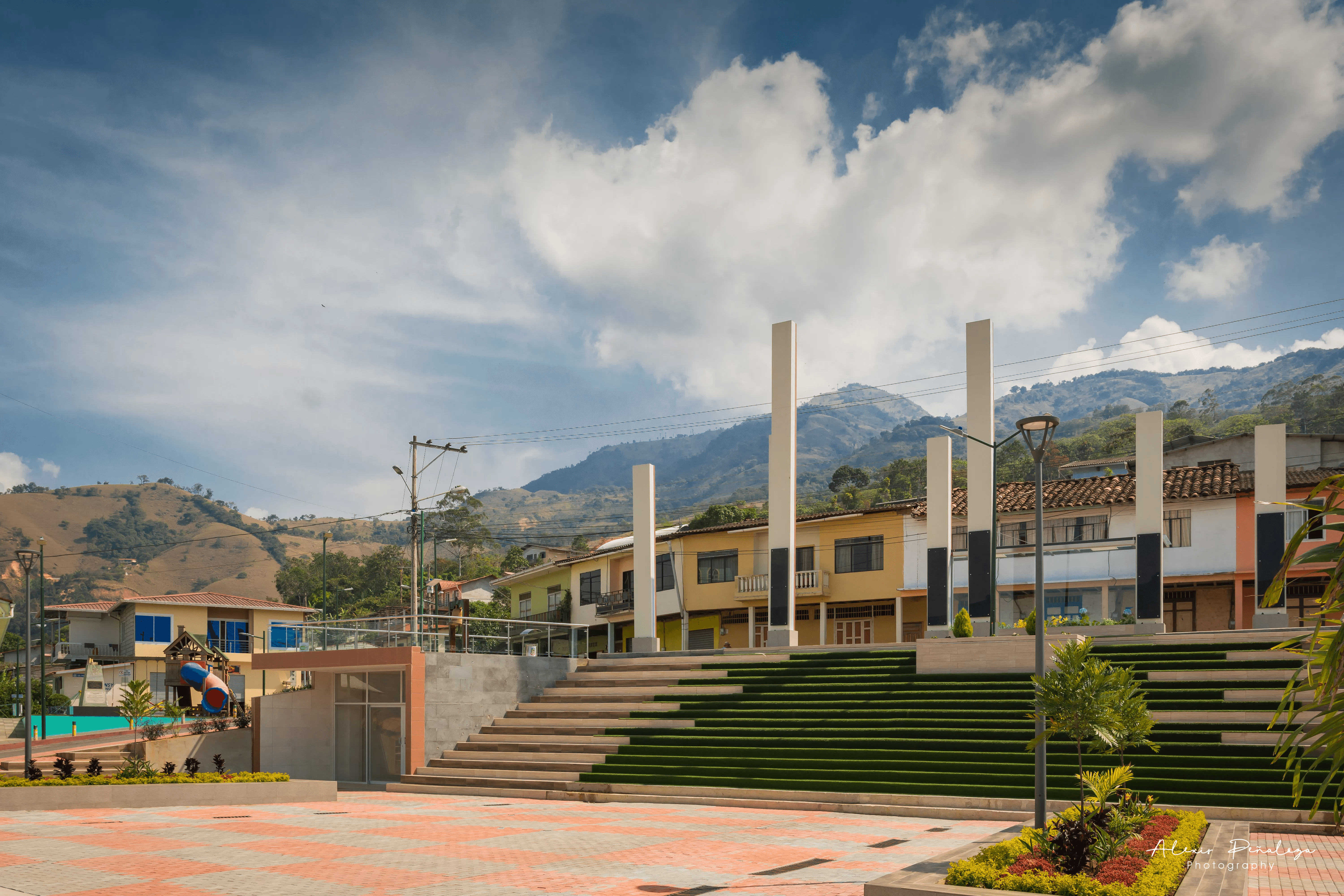 Centro moderno con altas columnas blancas y escalones cubiertos de césped sintético