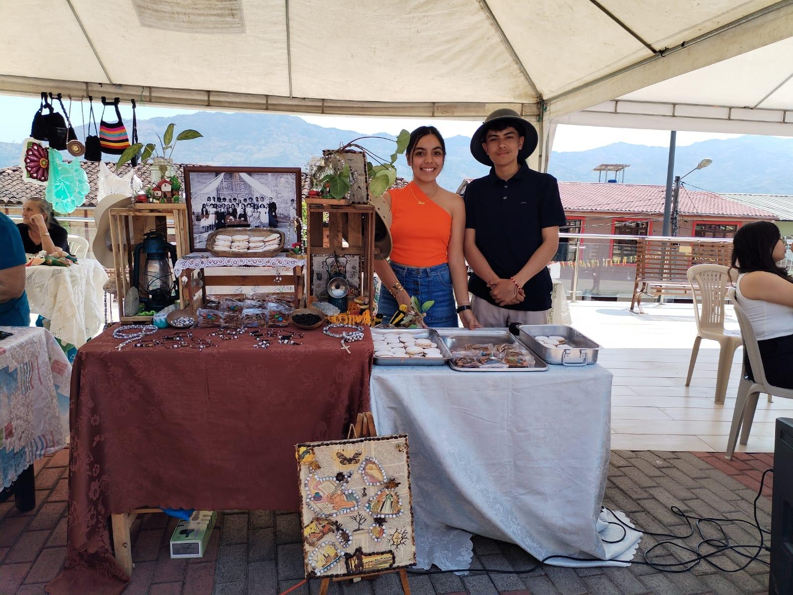Jóvenes emprendedores presentando productos artesanales y gastronómicos en su stand