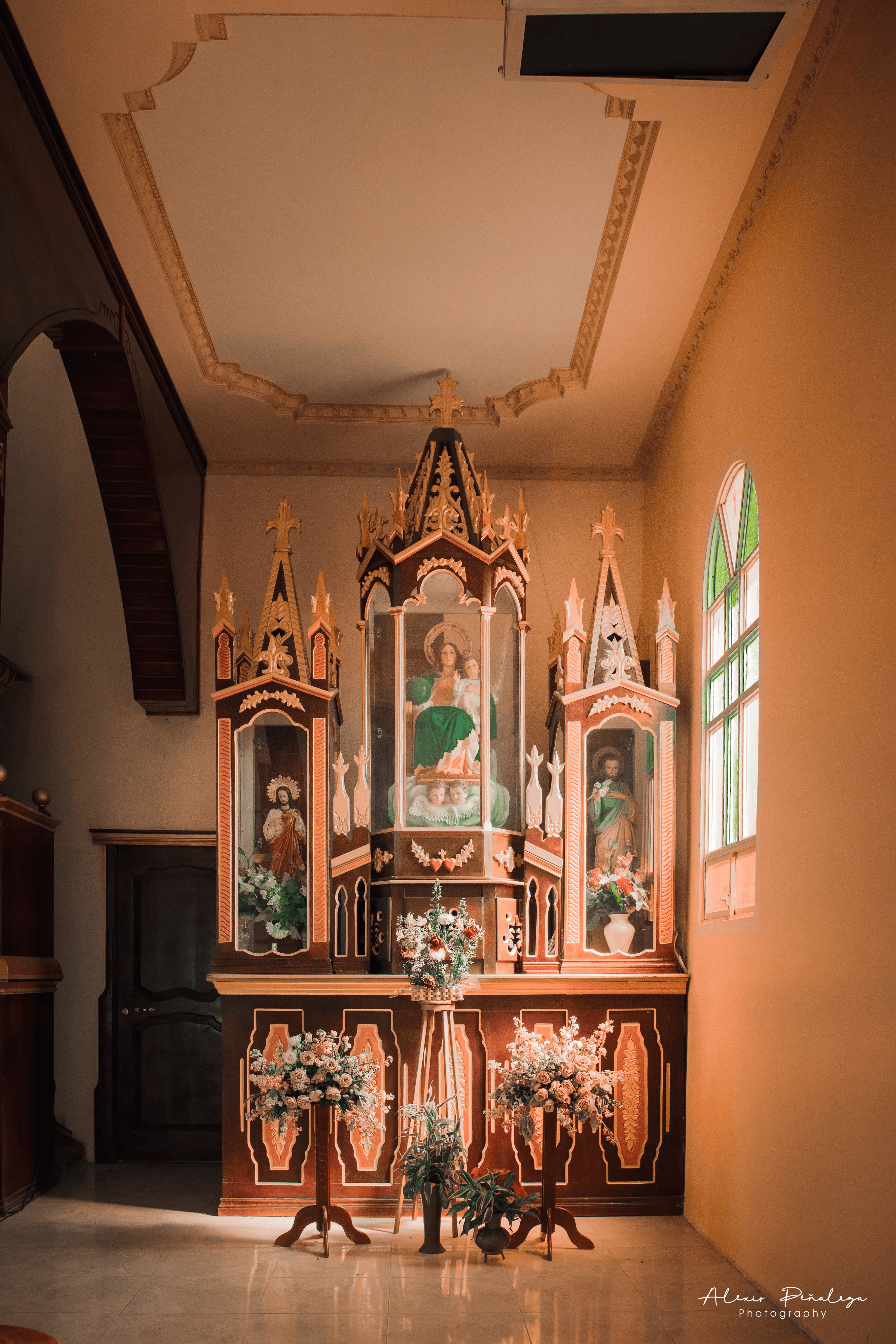 Altar menor tallado en madera con detalles dorados, la Virgen María y santos